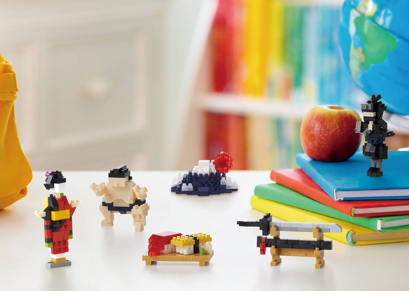 nanoblock sumo wrestler and dachshund models on a desk