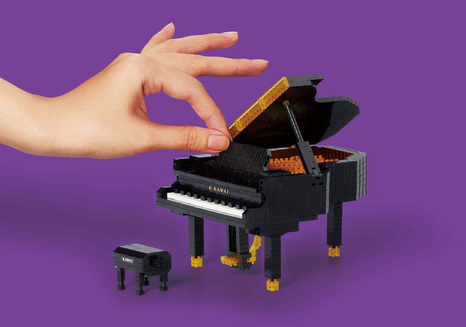 nanoblock grand piano being played with a fingertip