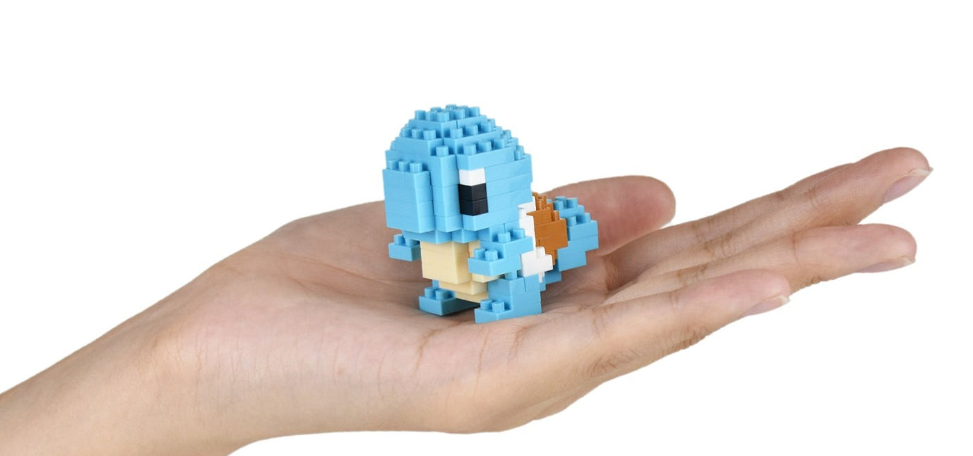 A finished nanoblock giraffe standing in the palm of a hand